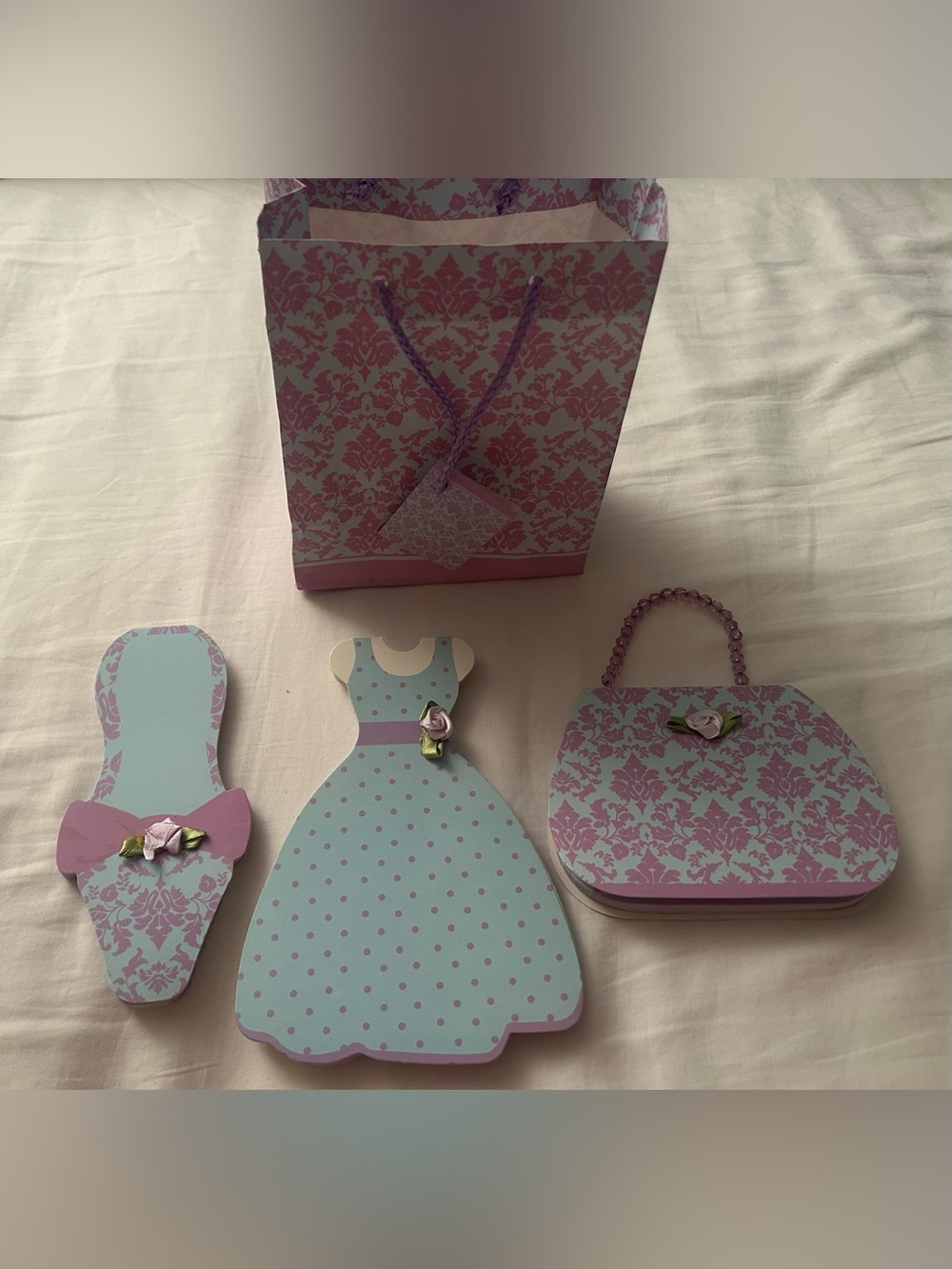 A set of decorative, die-cut paper pads shaped like a dress, shoe, and handbag.
